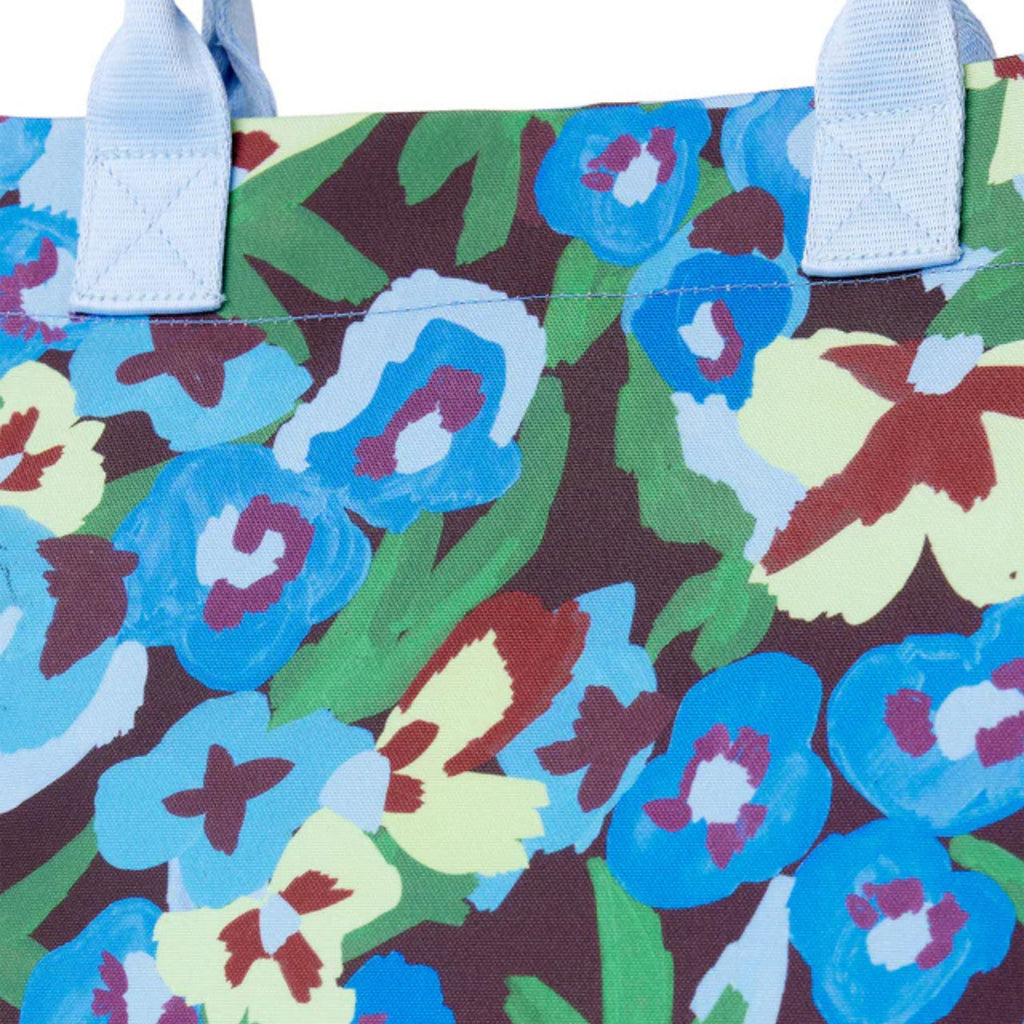 Close-up of a colorful floral-patterned bag with white handles.