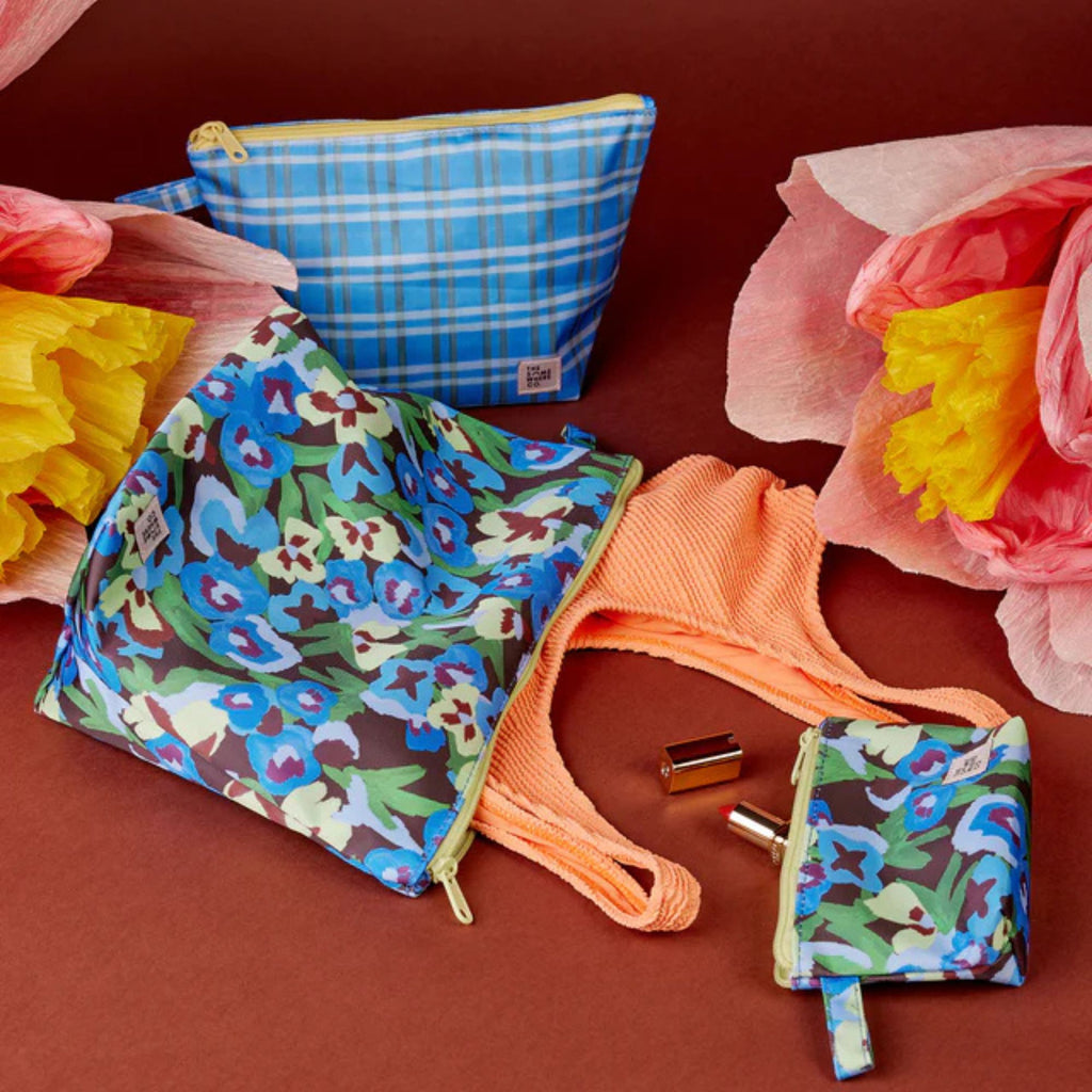 Colorful patterned bags and a strap on a red background with flowers.