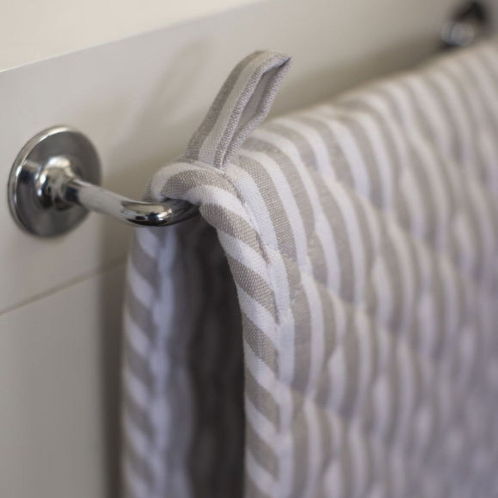 Gray and white striped towel hanging on a metal towel rack.