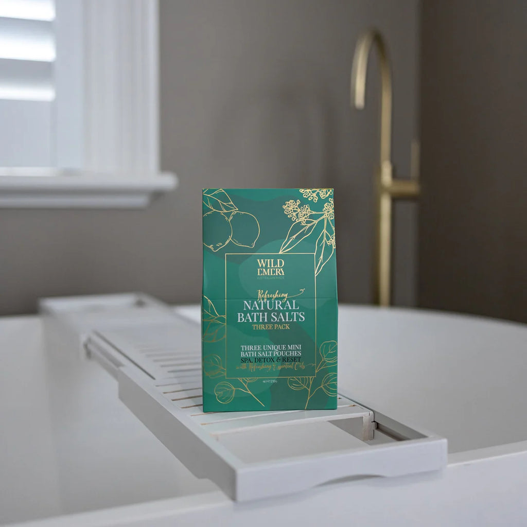 Box of Wild Elements bath salts on a bathtub ledge with a neutral background