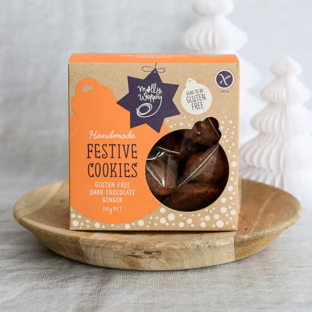 Box of Molly Woppy Festive Cookies on a wooden plate with a white background