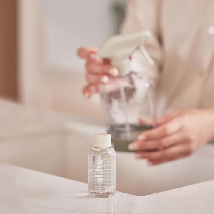 Person holding a glass with water next to a bottle on a surface