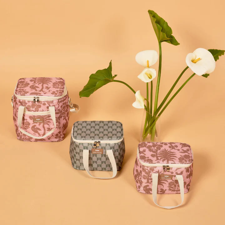 Three patterned bags on a beige background with white flowers.