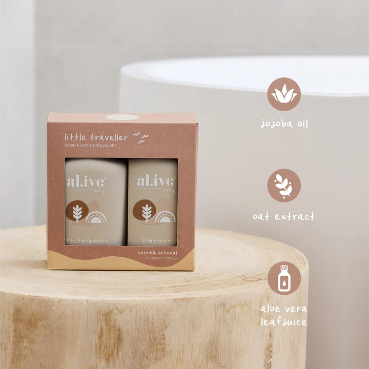 Two bottles of 'alive' baby products in a cardboard box on a wooden surface with ingredient icons and text.