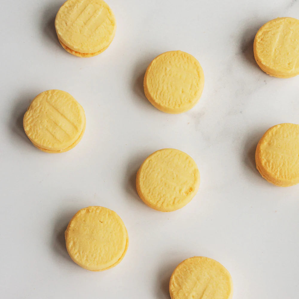 Yellow cookies arranged on a white surface