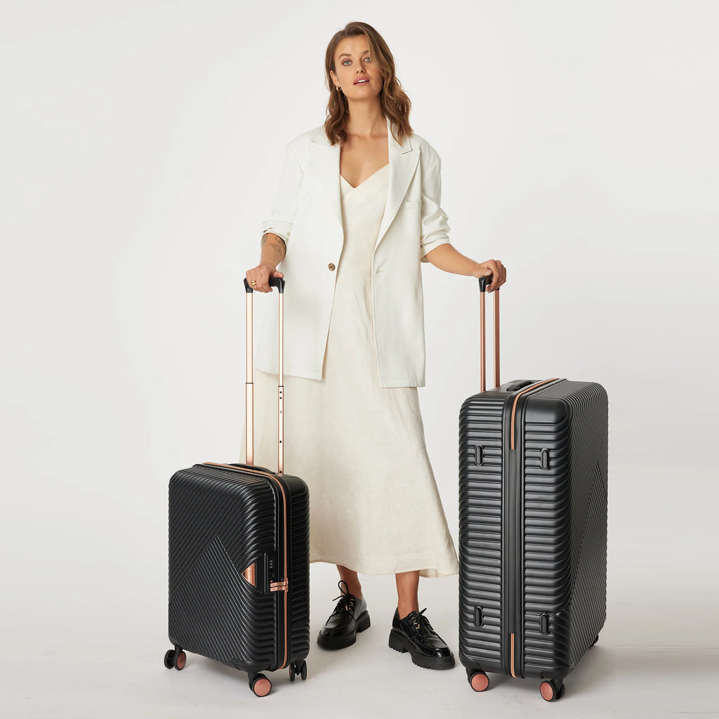 Woman holding two black suitcases with a white background