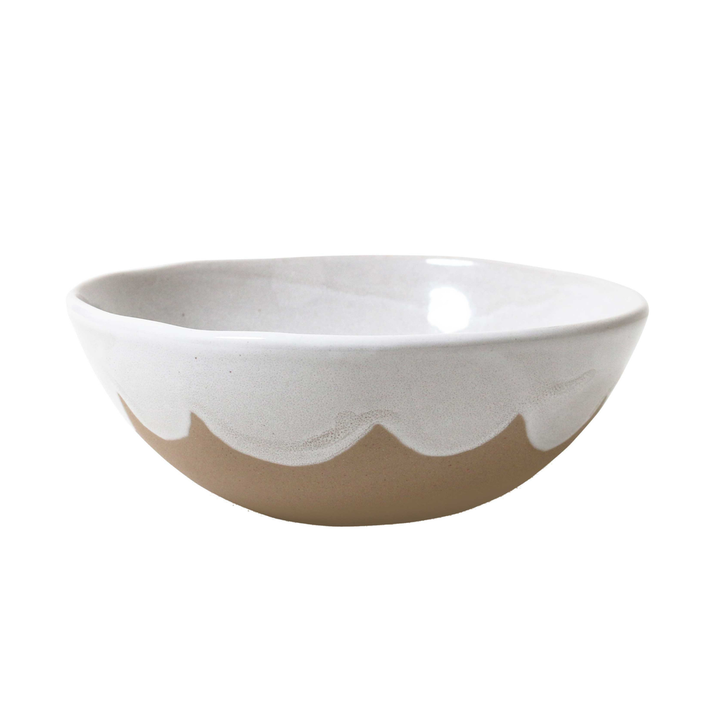 A brown ceramic bowl with a white glaze inner and top with a scalloped edge against a white background 