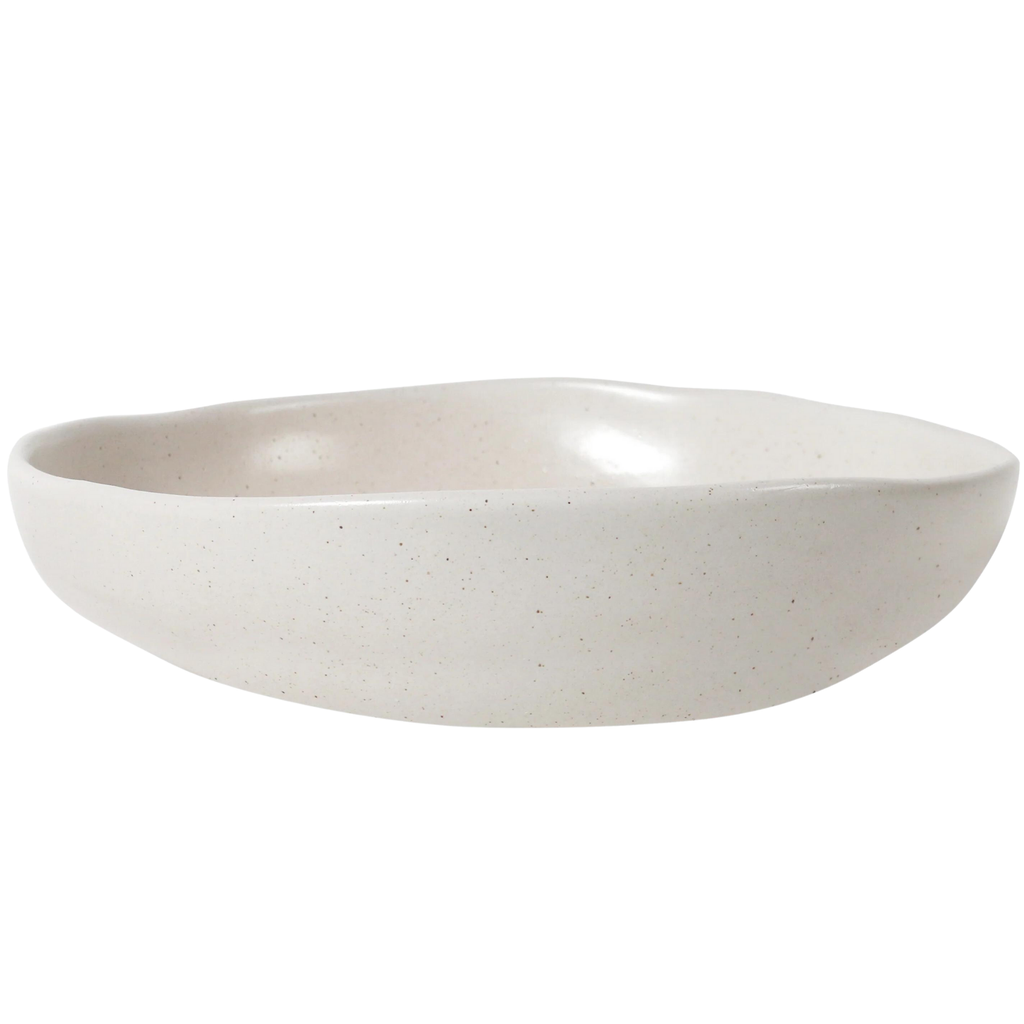 A flat and wide white ceramic serving bowl against a white background