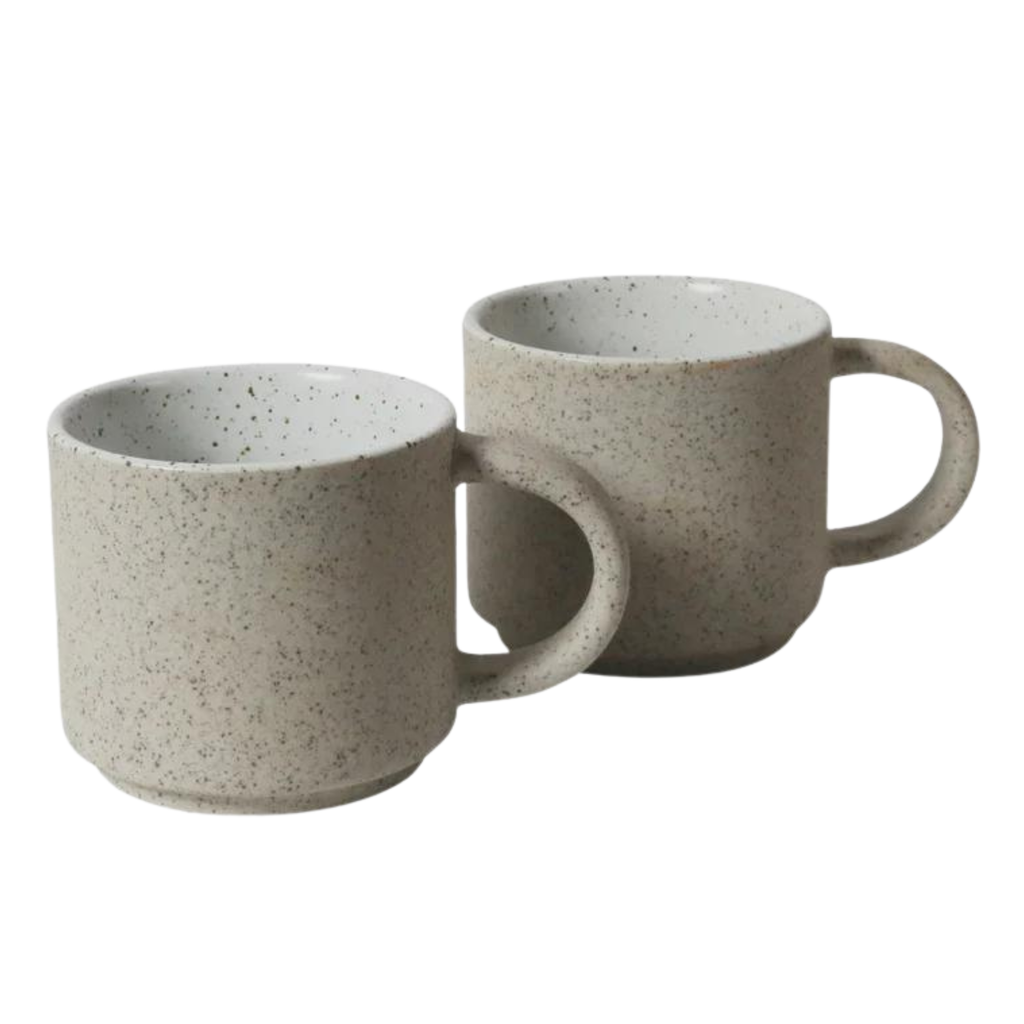 Two ceramic mugs with handles made of a grey clay with speckles and a white glaze with black speckles on the inner mug on a white background