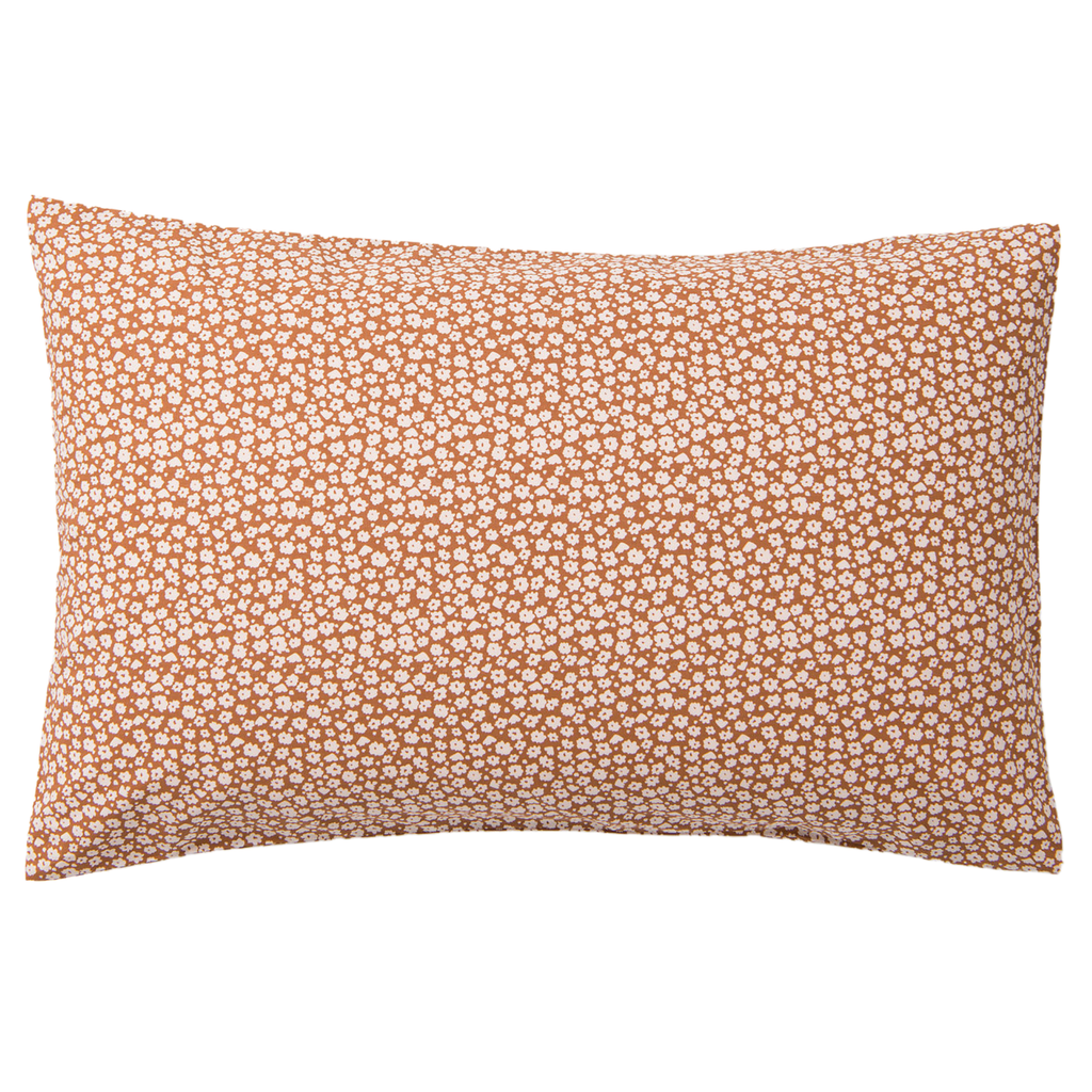 A orange bed pillow with white flowers on it