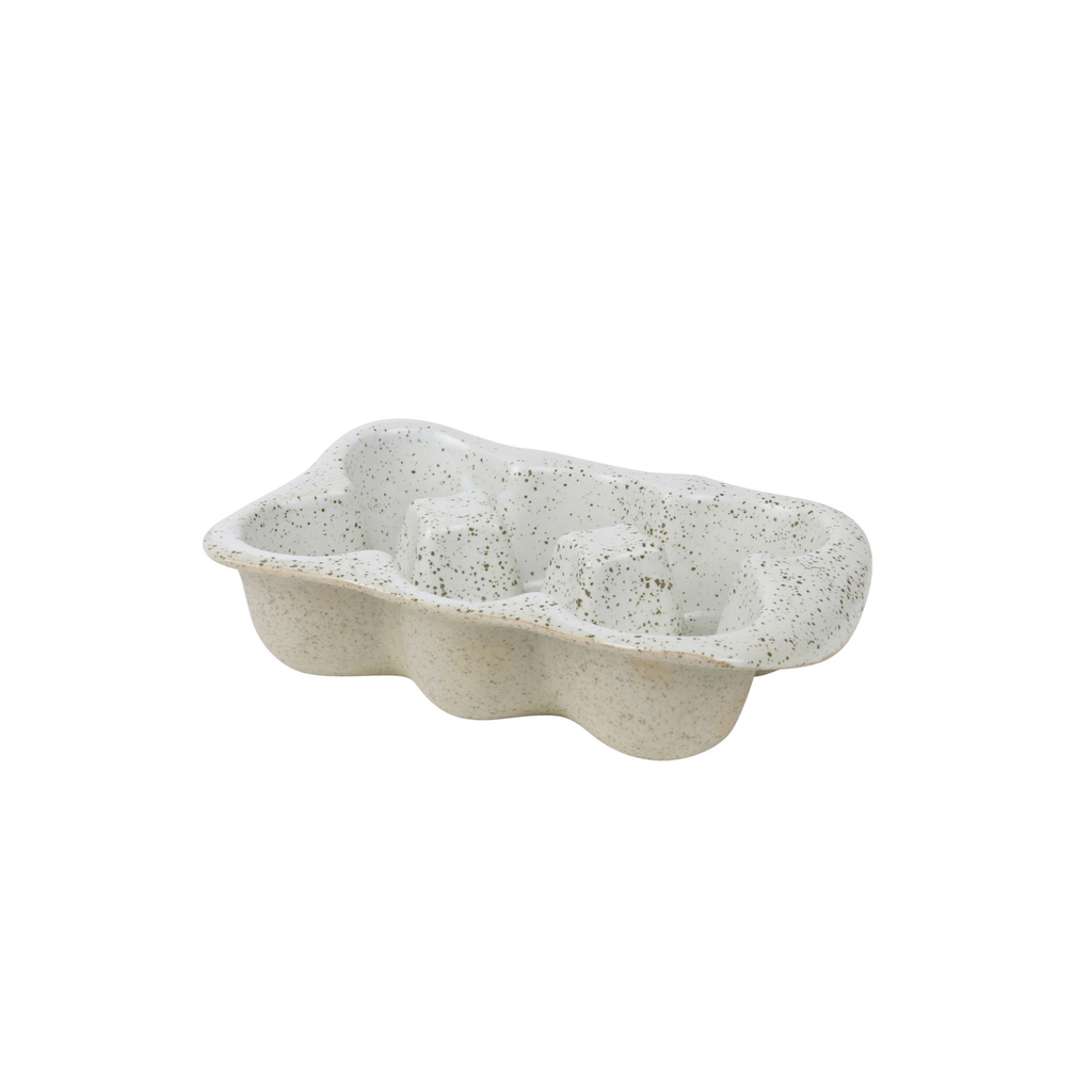 A ceramic 6 egg cartoon made of beige clay with black speckles with a white and black specked glaze on the inside